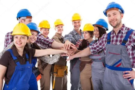 Bauteam im Gespräch mit Schutzhelmen und Unterlagen